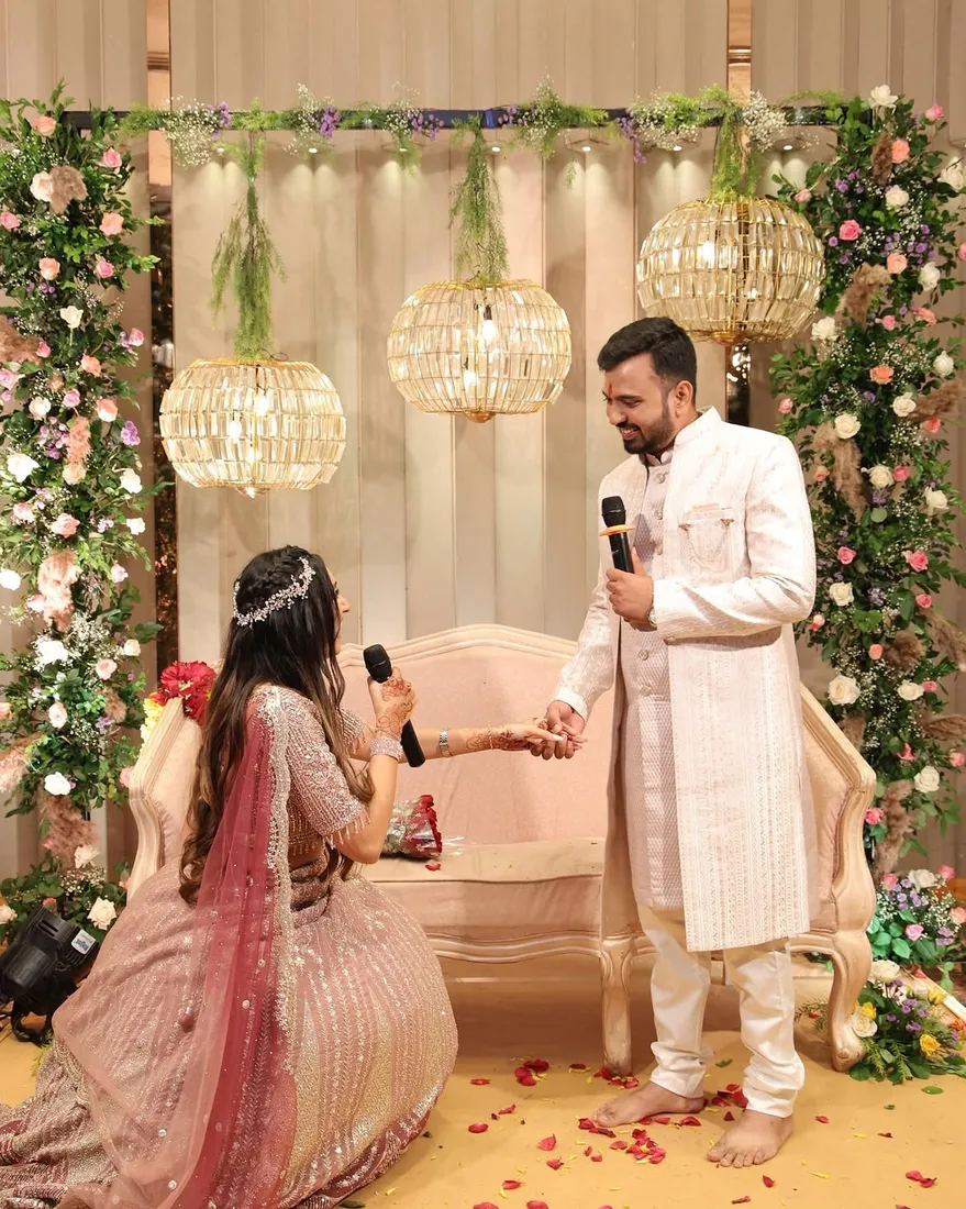 Wedding couple exchanging rings at a floral arch