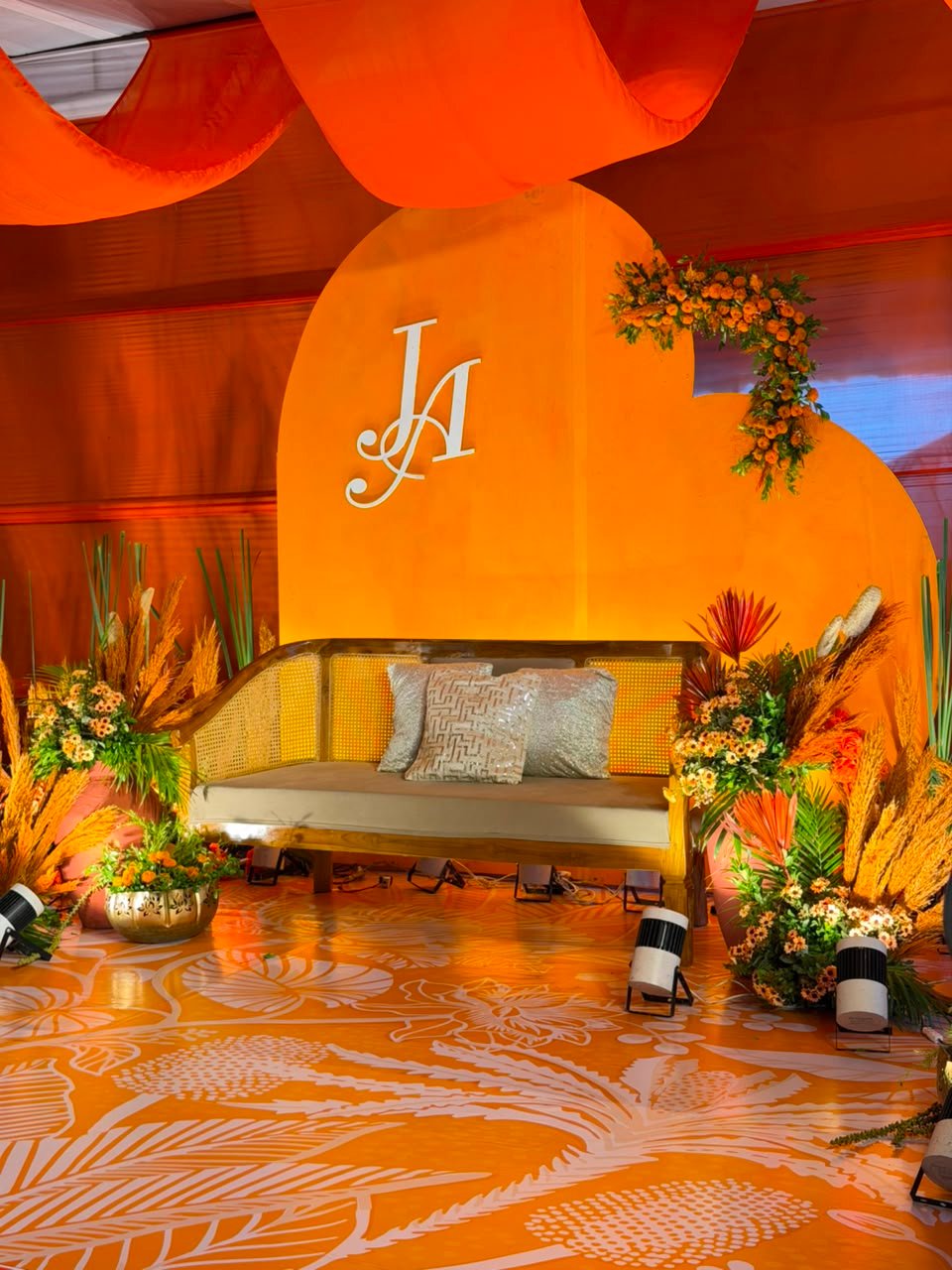 Marigold and pampas mehndi stage with heart-shaped monogram backdrop