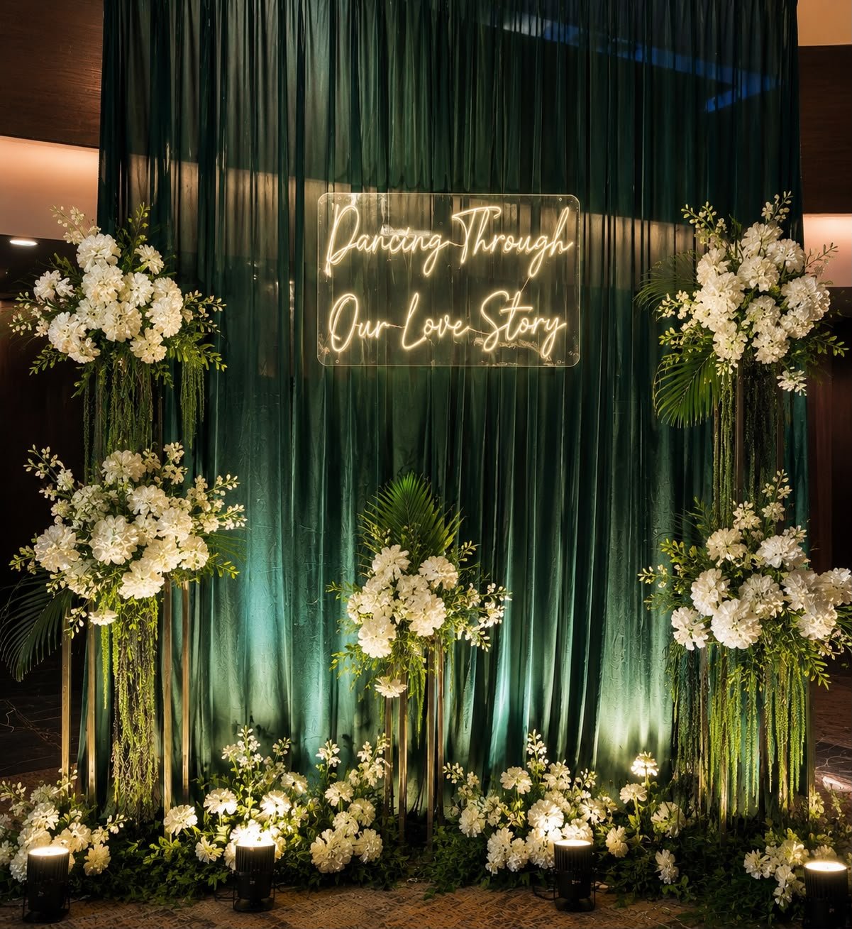 Emerald velvet sangeet backdrop with neon sign and white florals